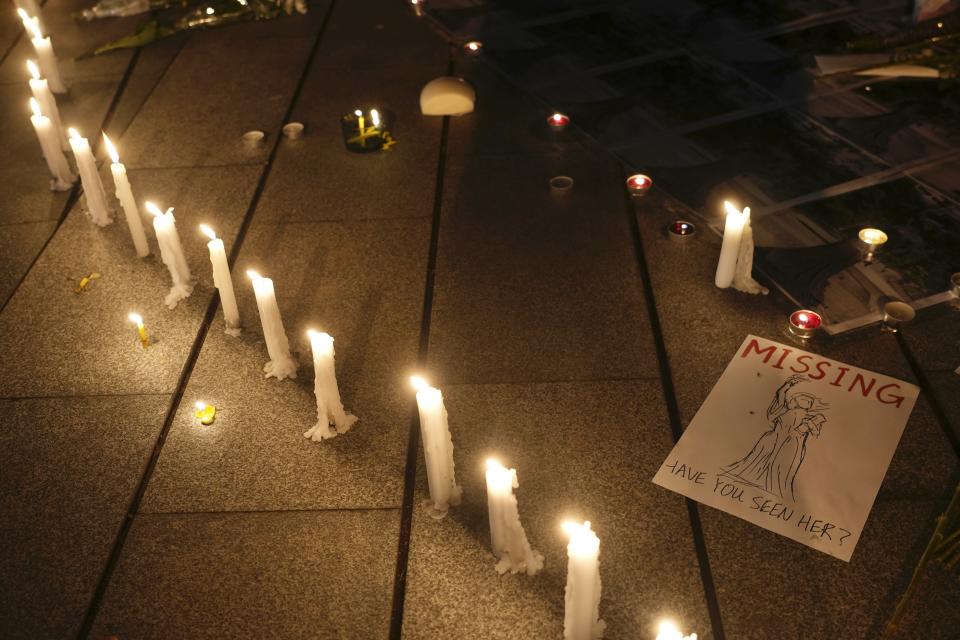 University students light candles at the site after the "Goddess of Democracy" statue, a memorial for those killed in the 1989 Tiananmen crackdown, was removed from the Chinese University of Hong Kong, Friday, Dec. 24, 2021. The university early Friday morning took down the statue that was based on a figure created by art students and brought to the square shortly before the crackdown in which hundreds of people were killed. (AP Photo/Vincent Yu)