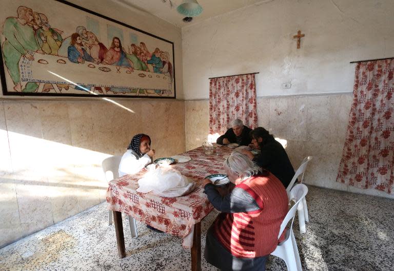 Syrian Christians share a meal at the Saint Elias centre for the elderly in the rebel-held side of Aleppo on November 18, 2014