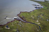 Work crews use booms and vacuums to clean marshland impacted by oil from the Deepwater Horizon Spill near Bay Jimmy, in the Barataria Bay of Louisiana June 17, 2010. REUTERS/Lee Celano