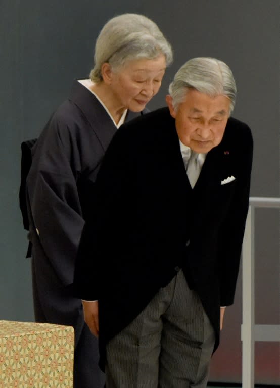 Japan's Emperor Akihito (R) and Empress Michiko (L) bow to people as they leave the official annual memorial service for war victims in Tokyo