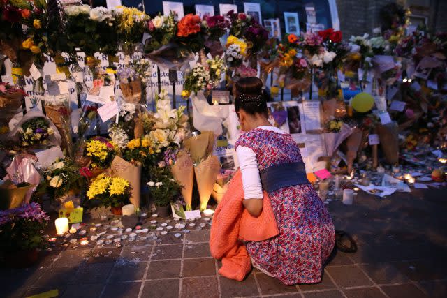 People look at tributes at Notting Hill Methodist Church near Grenfell Tower (Isabel Infantes/PA)