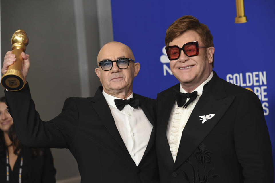 Elton John, right, and Bernie Taupin pose in the press room with the award for best original score in a motion picture for "I'm Gonna Love Me Again" from "Rocketman" at the 77th annual Golden Globe Awards at the Beverly Hilton Hotel on Sunday, Jan. 5, 2020, in Beverly Hills, Calif. (AP Photo/Chris Pizzello)