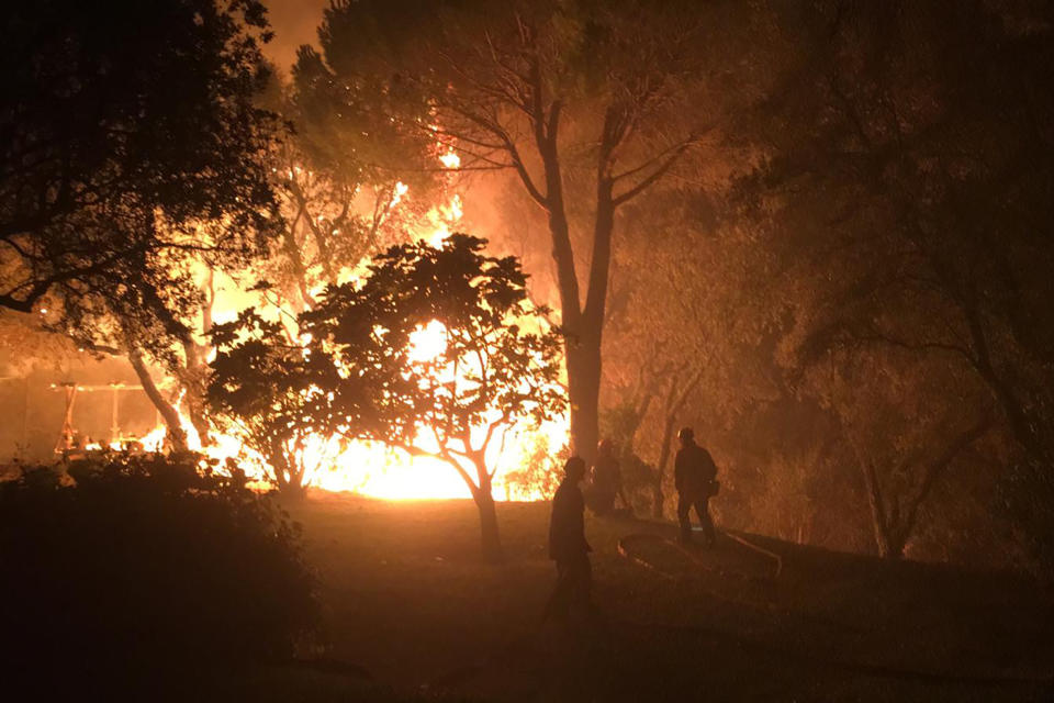 In this photo provided by the fire brigade of the Var region, firemen battle with a wildfire near Toulon early Tuesday, Aug. 17, 2021. Hundreds of firefighters on Tuesday battled a fire racing through forests near the French Riviera that forced the evacuation of thousands of people from homes and vacation spots. (SDIS 83 via AP)