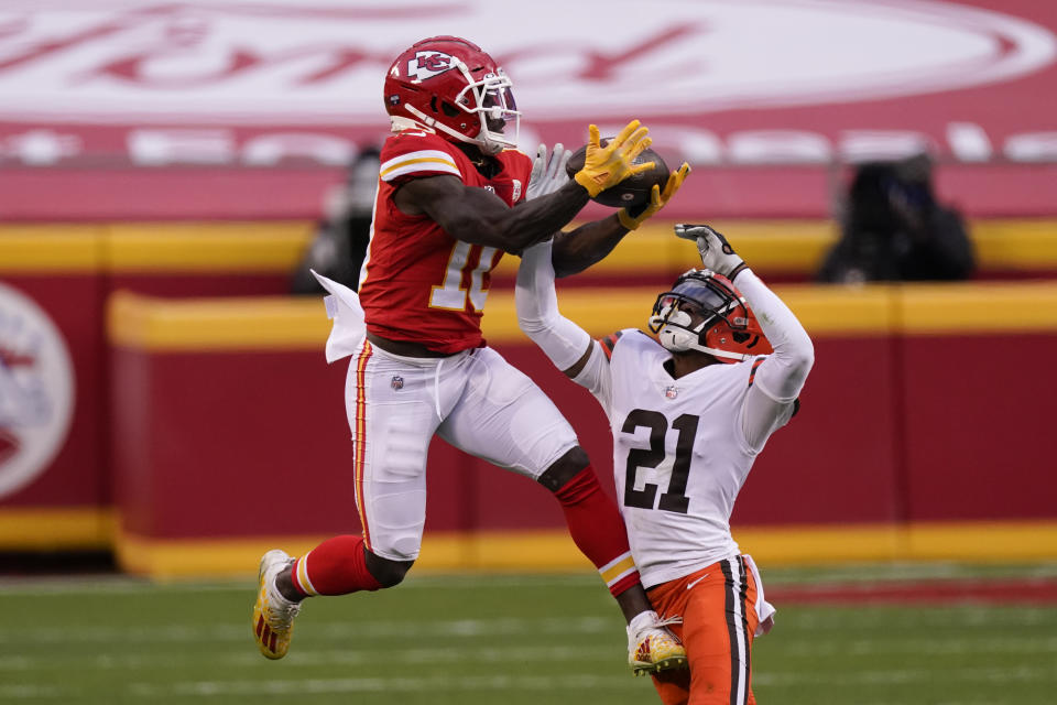 Kansas City Chiefs wide receiver Tyreek Hill makes a catch over Cleveland Browns cornerback Denzel Ward (21) during the second half of an NFL divisional round football game, Sunday, Jan. 17, 2021, in Kansas City. (AP Photo/Charlie Riedel)