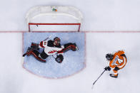 Philadelphia Flyers' Sean Couturier (14) gets a shot past New Jersey Devils' Scott Wedgewood (41) during the second period of an NHL hockey game, Monday, May 10, 2021, in Philadelphia. (AP Photo/Matt Slocum)