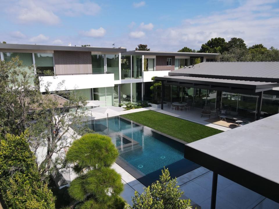 A backyard with a covered patio and pool.