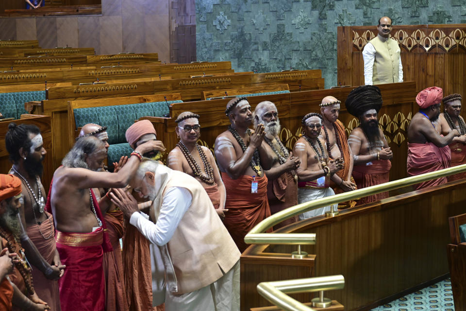Indian prime minister Narendra Modi greets Hindu priests after installing a royal golden sceptre near the chair of the speaker, during the start of the inaugural ceremony of the new parliament building, in New Delhi, India, Sunday, May 28, 2023. The new triangular parliament building, built at an estimated cost of $120 million, is part of a $2.8 billion revamp of British-era offices and residences in central New Delhi called "Central Vista", even as India's major opposition parties boycotted the inauguration in a rare show of unity against the Hindu nationalist ruling party that has completed nine years in power and is seeking a third term in crucial general elections next year. (AP Photo)