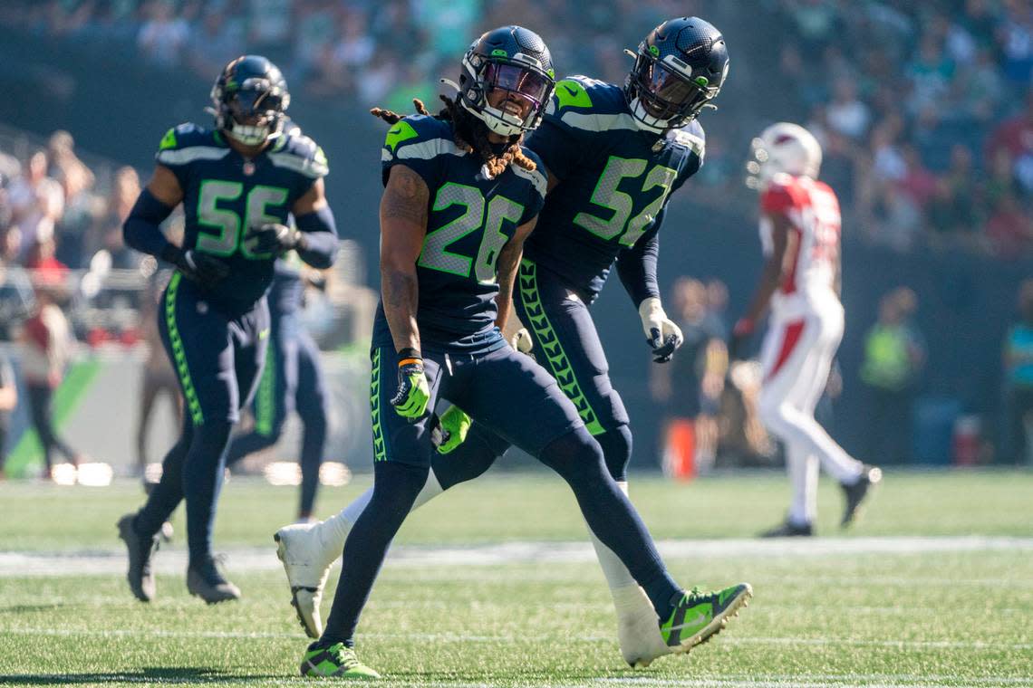 Seattle Seahawks safety Ryan Neal (26) and defensive end Darrell Taylor (52) celebrate after Neal sacked Arizona Cardinals quarterback Kyler Murray (1) during the second quarter of an NFL game on Sunday, Oct. 16, 2022, at Lumen Field in Seattle.