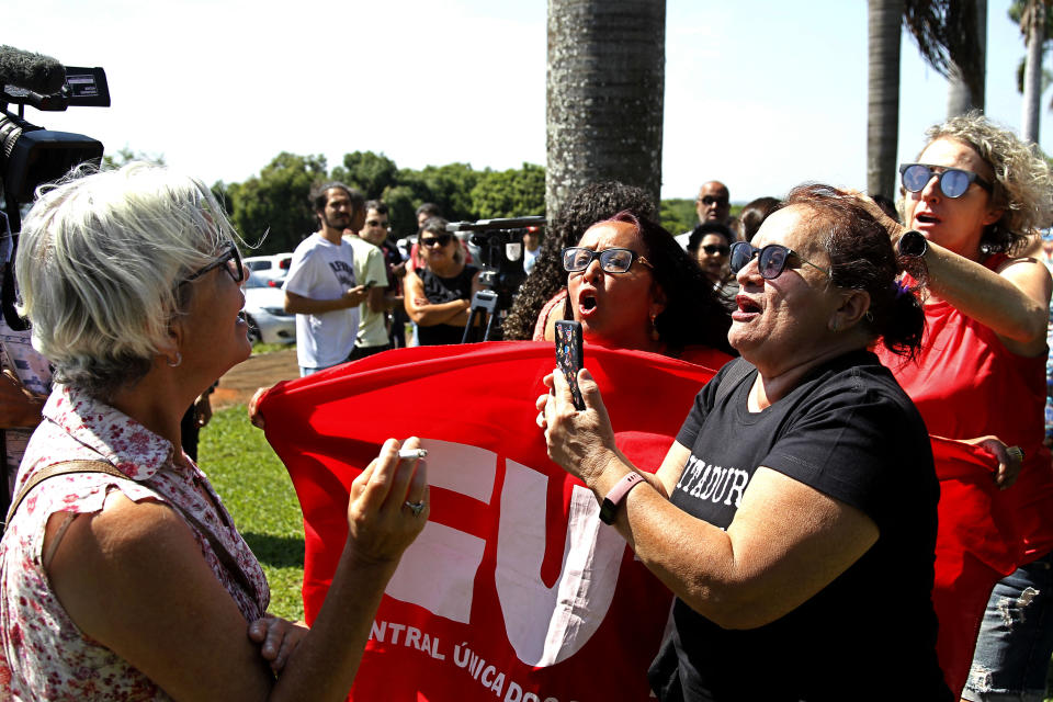 A supporter of the Venezuelan opposition leader and self-proclaimed interim president Juan Guaido, left, argues with supporters of Venezuelan President Nicolas Maduro, outside the Venezuelan Embassy in Brasilia, Brazil, Wednesday, Nov. 13, 2019. A group of people backing Guaido occupied the nation’s embassy in Brasilia, on Wednesday. (AP Photo/Beto Barata)