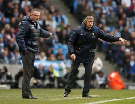 Manchester City manager Manuel Pellegrini (R) and his Aston Villa counterpart Paul Lambert react during their English Premier League soccer match at the Etihad Stadium in Manchester, northern England May 7, 2014. REUTERS/Phil Noble