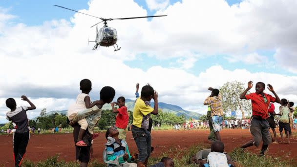 PHOTO: Children in Mulanje look on as a military helicopter carry doctors and medical supplies to Muloza on the border with Mozambique which are cut off after the tropical Cyclone Freddy outside Blantyre, Malawi, March 18, 2023. (Esa Alexander/Reuters)