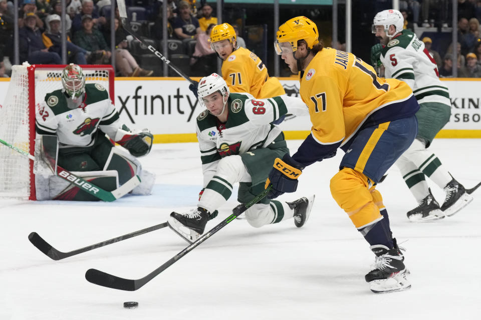 Nashville Predators center Mark Jankowski (17) closes in against Minnesota Wild goaltender Filip Gustavsson (32) and Damien Giroux (68) during the second period of an NHL hockey game Thursday, April 13, 2023, in Nashville, Tenn. (AP Photo/Mark Humphrey)