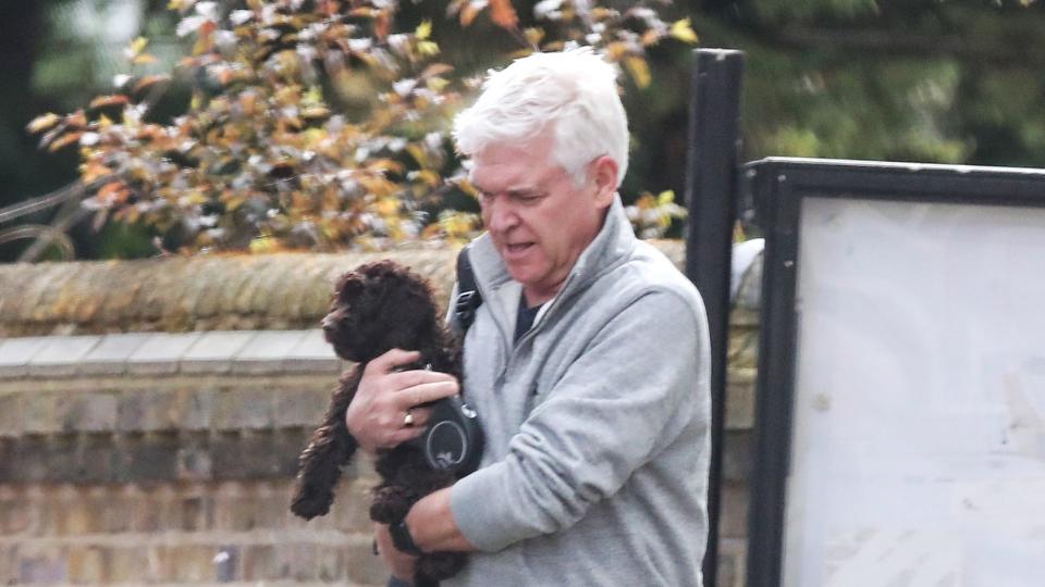 Phillip could be seen holding the cockapoo in his arms