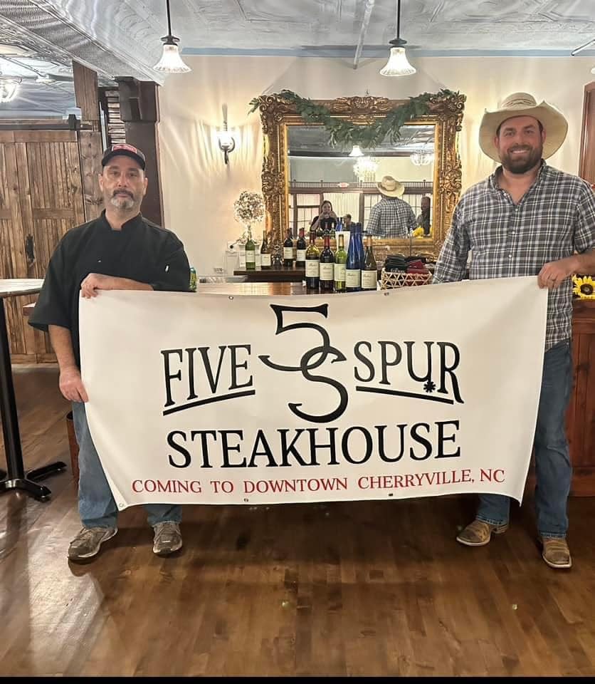 Stephen Soto and Johnny Ray hold the sign for their incoming steakhouse.