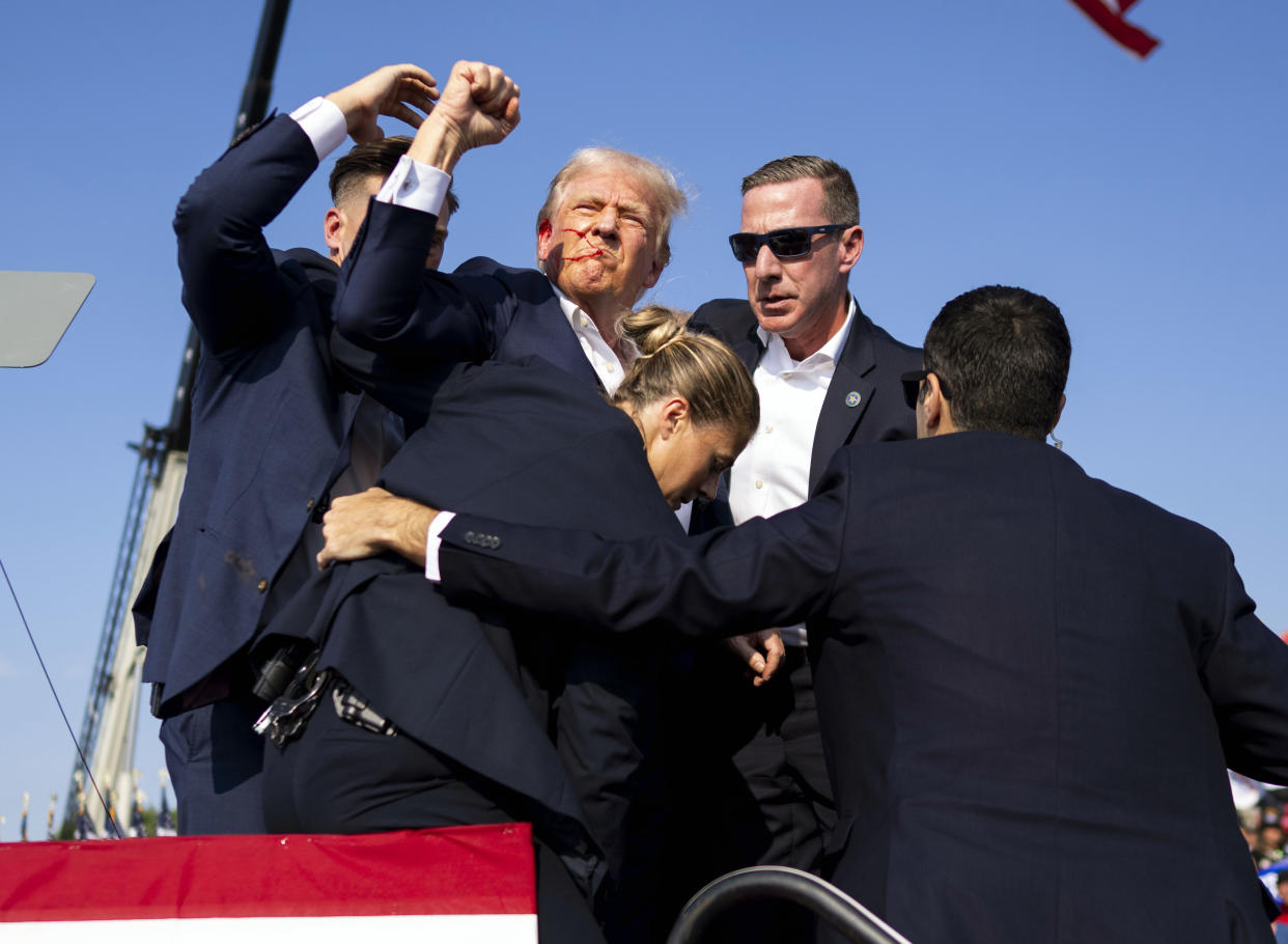 A bloodied Donald Trump is surrounded by Secret Service agents after shots were fired at a campaign rally on Saturday, July 13 2024, in Butler, Pa.  (Doug Mills/The New York Times)