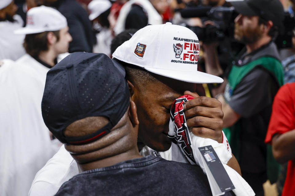 North Carolina State's DJ Horne, right, is hugged by his father, Lamar, following an Elite Eight college basketball game in the NCAA Tournament in Dallas, Sunday, March 31, 2024. North Carolina State won 76-64. (AP Photo/Brandon Wade)