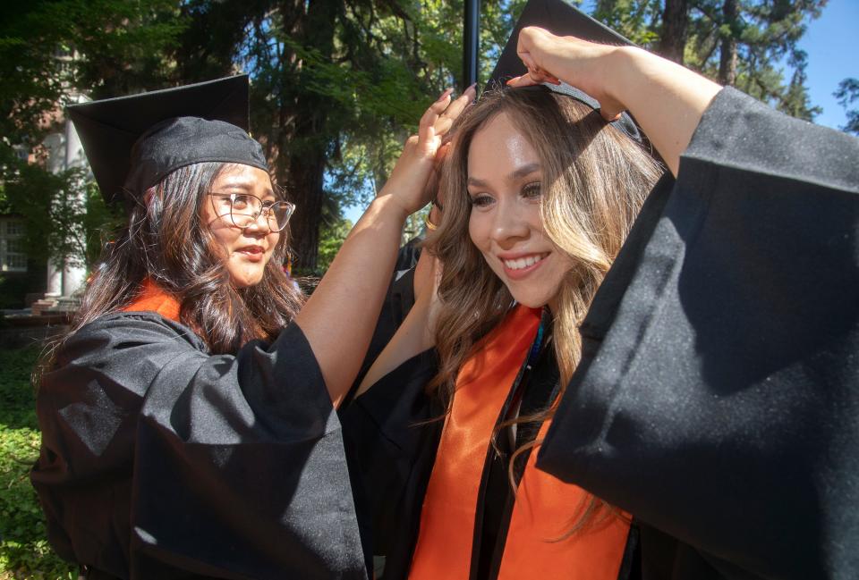 University of the Pacific graduate Quinnalen Poe, left, helps fellow grad Cassandra Andrade with her cap before the start of commencement ceremonies.