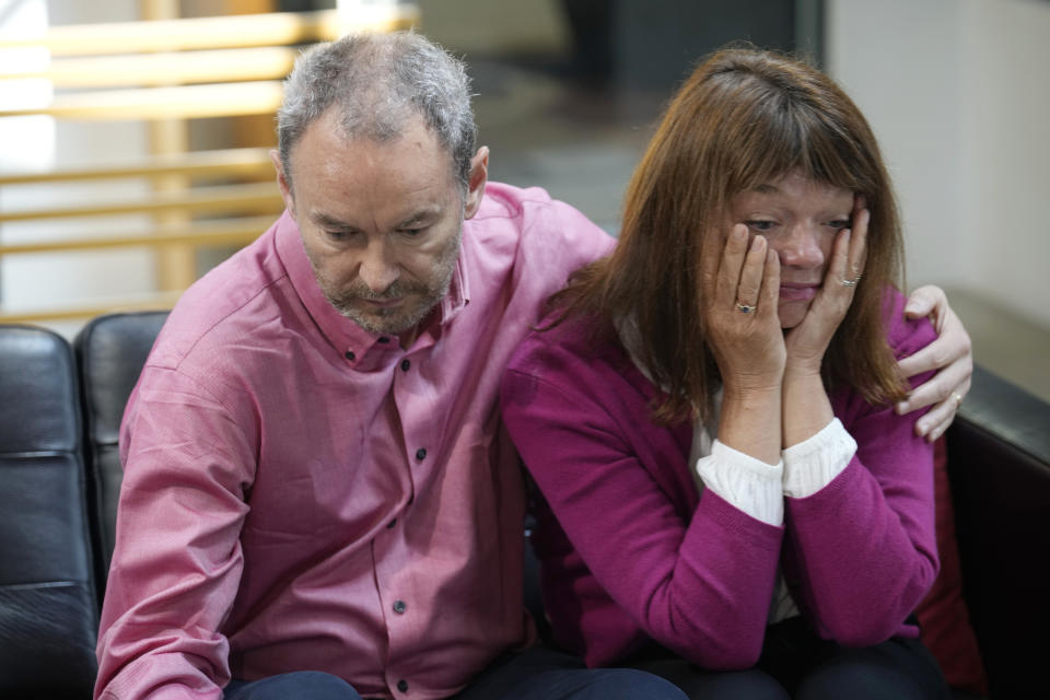 Simon Glass, left, and his wife, Sally Glass, embrace as they talk about the $19 million settlement from state and local law enforcement agencies for the killing of the couple's 22-year-old son, Christian, in June 2022, while he suffered a mental health crisis on Tuesday, May 23, 2023, during a news interview in the offices of the couple's lawyers in Denver. As part of the settlement, training for law officers will change as well. (AP Photo/David Zalubowski)