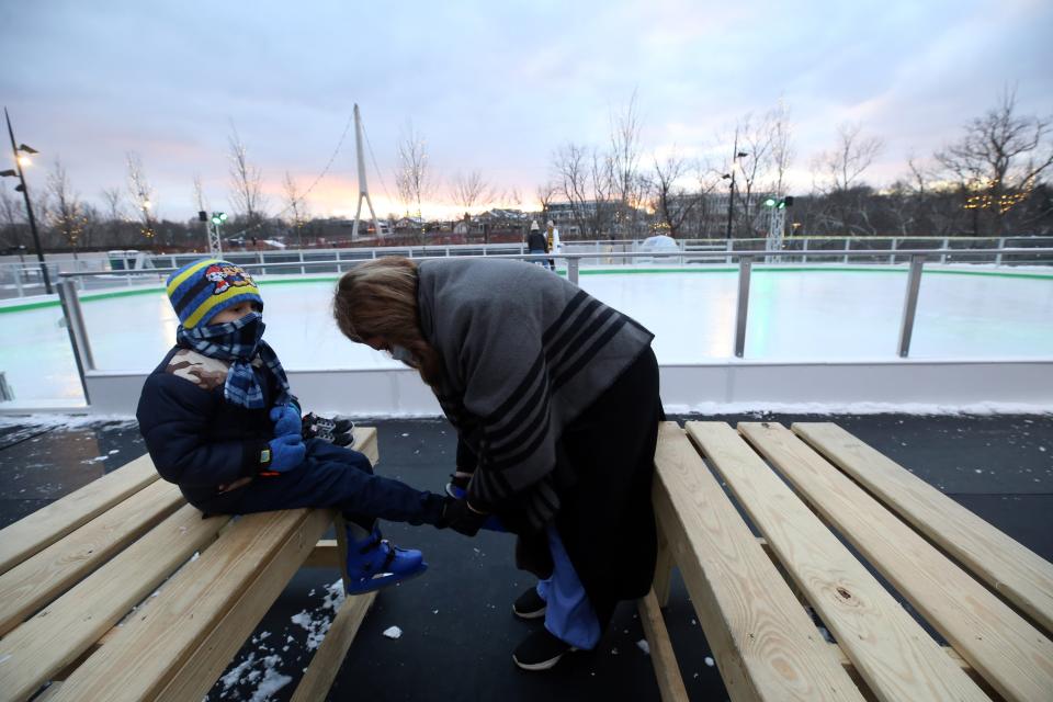 Rajveer Dhillon, 6, gets some help putting on his skates from his mother, Ella, before heading out to the ice rink.