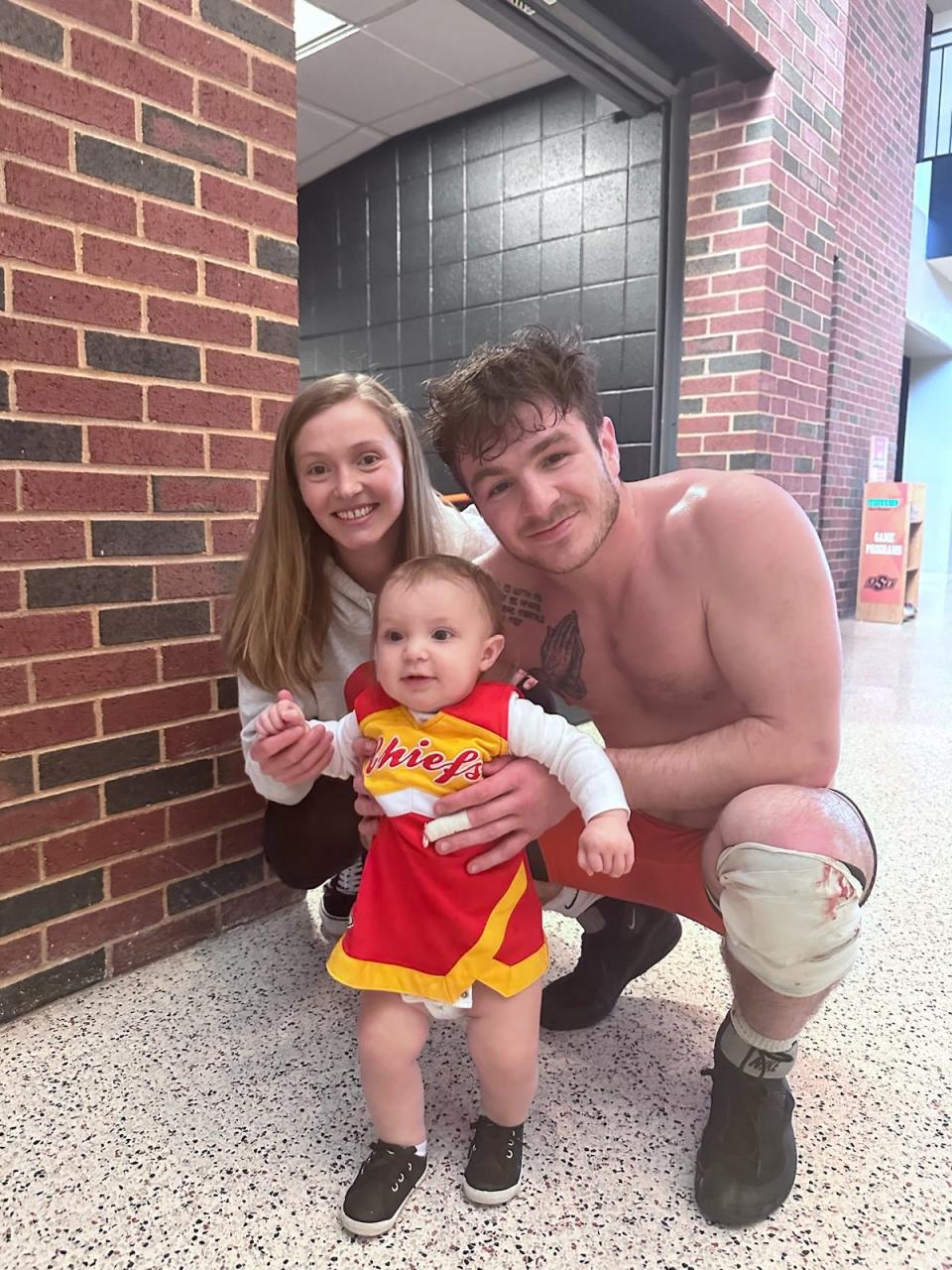 Oklahoma State wrestler Kaden Gfeller, right, with his fiance, Cassidy Watters, and daughter Charlotte.