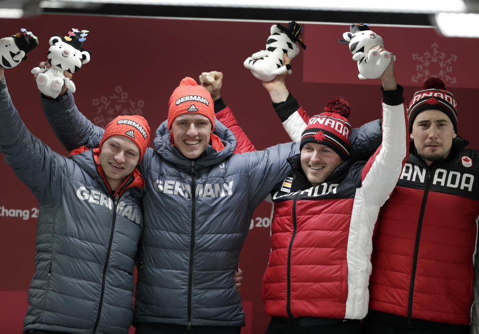 Germany and Canada celebrate gold in the two-man bobsled final at the 2018 Winter Olympics in Pyeongchang, South Korea. (AP)