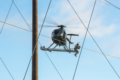 A PPL Electric Utilities employee installs a Dynamic Line Rating (DLR) sensor onto a transmission line from a helicopter. (PRNewsfoto/PPL Electric Utilities)