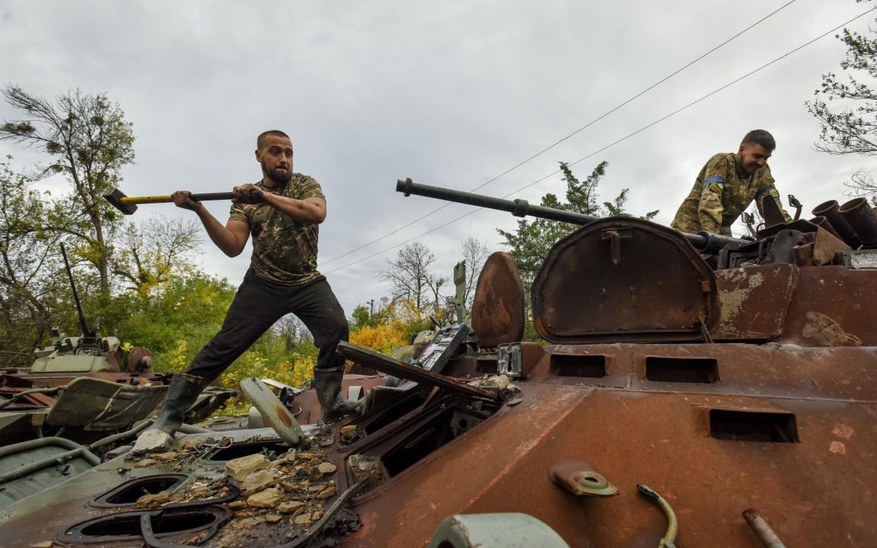Ukrainian soldiers collect spare parts from a burned Russian APC - OLEG PETRASYUK/EPA-EFE/Shutterstock 