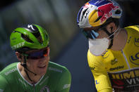Belgium's Wout Van Aert, wearing the overall leader's yellow jersey speak with Netherlands' Fabio Jakobsen, wearing the best sprinter's green jersey at the start of the fourth stage of the Tour de France cycling race over 171.5 kilometers (106.6 miles) with start in Dunkerque and finish in Calais, France, Tuesday, July 5, 2022. (AP Photo/Daniel Cole )