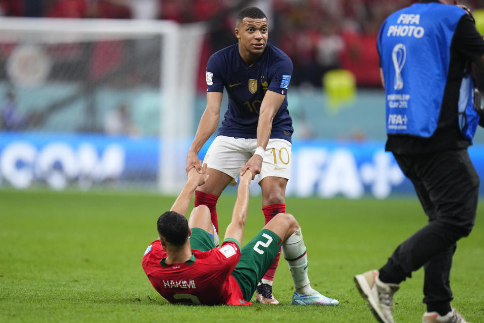 France's Kylian Mbappe helps Morocco's Achraf Hakimi up at the end of the World Cup semifinal soccer match between France and Morocco at the Al Bayt Stadium in Al Khor, Qatar, Wednesday, Dec. 14, 2022. France won 2-0 and will play Argentina in Sunday's final. (AP Photo/Manu Fernandez)