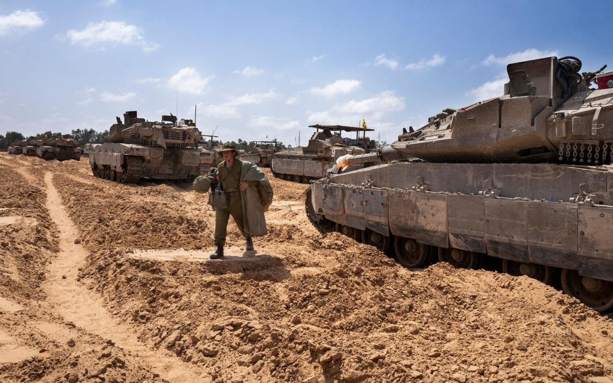 An Israeli soldier makes his way to his tanks