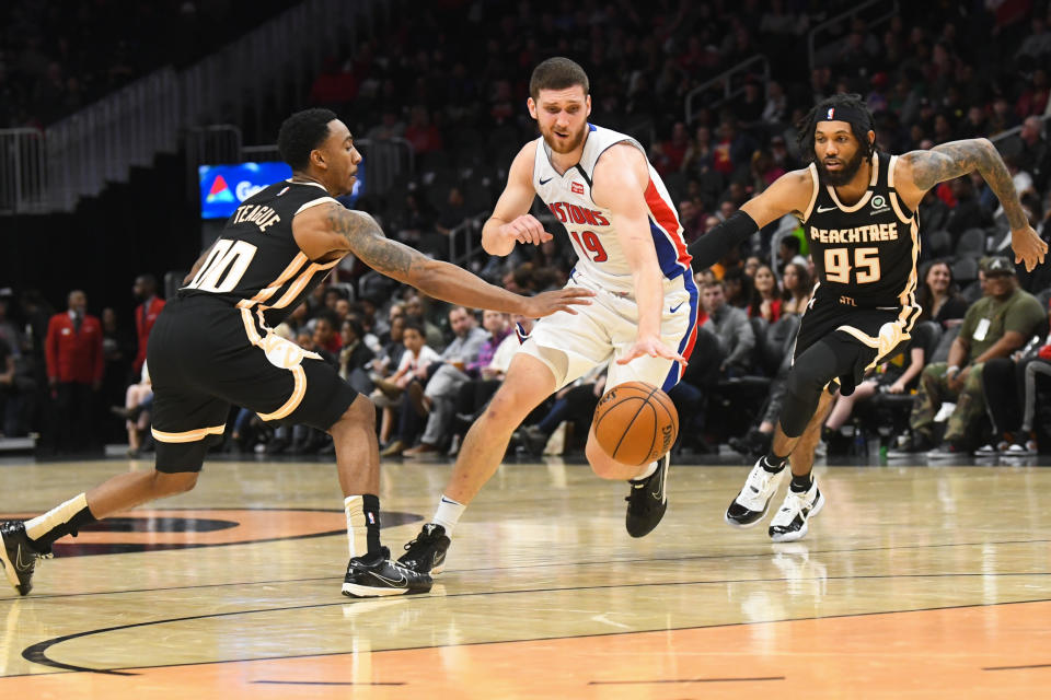 Detroit Pistons guard Sviatoslav Mykhailiuk, center, tries to split the defense of Atlanta Hawks guards Jeff Teague (00) and DeAndre' Bembry (95) during the second half of an NBA basketball game Saturday, Jan. 18, 2020, in Atlanta. (AP Photo/John Amis)