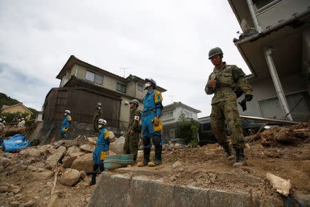 Rescue workers and Japan Self-Defense Force soldiers search for missing people at a landslide site after heavy rain in Kumano Town, Hiroshima Prefecture, western Japan, July 11, 2018. REUTERS/Issei Kato