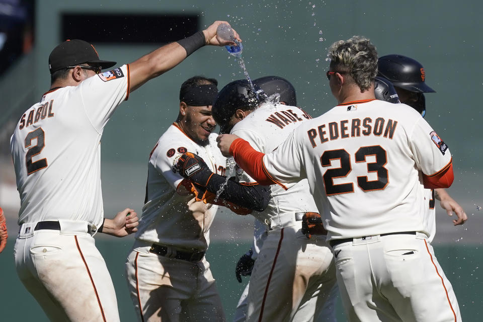 San Francisco Giants' LaMonte Wade Jr., middle, is congratulated by teammates after hitting a sacrifice fly that scored Patrick Bailey during the tenth inning of a baseball game against the Cleveland Guardians in San Francisco, Wednesday, Sept. 13, 2023. (AP Photo/Jeff Chiu)