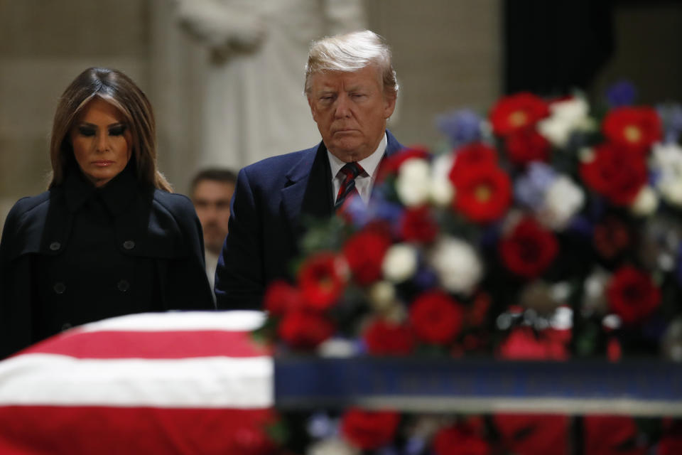 President Donald Trump and first lady Melania Trump pay their respects to former President George H. W. Bush, as he lies in state in the Rotunda of the U.S. Capitol, Monday, Dec. 3, 2018, in Washington.