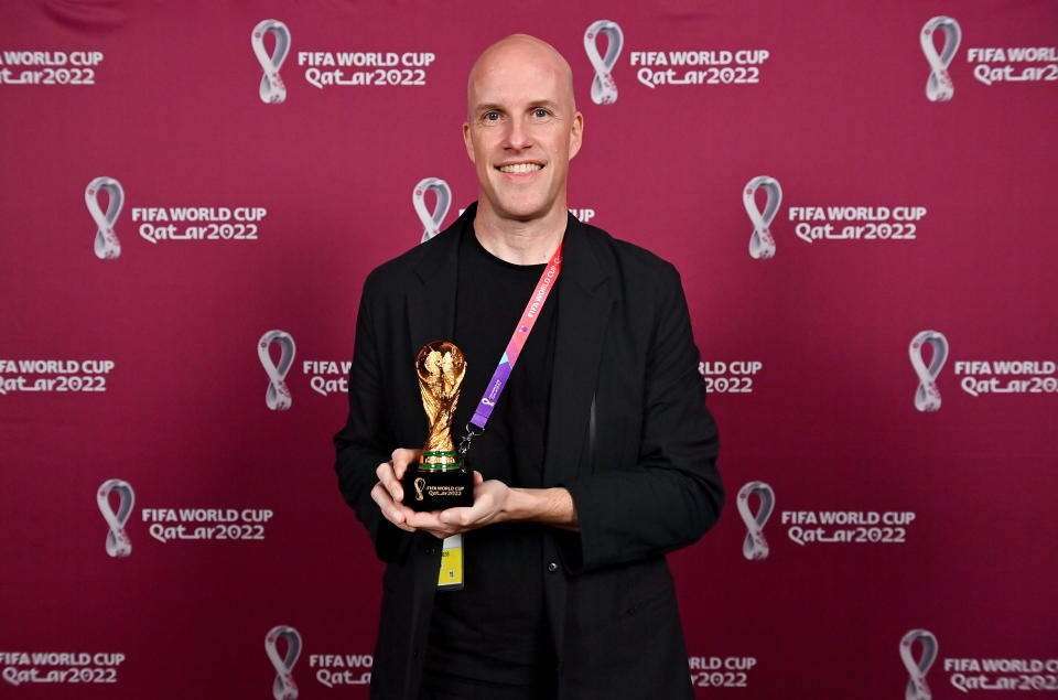 DOHA, QATAR - NOVEMBER 26: Grant Wahl with a world cup replica trophy, in recognition of their achievement of covering 8 or more FIFA World Cups, during an AIPS / FIFA Journalist on the Podium ceremony at the Main Media Centre on November 29, 2022 in Doha, Qatar. (Photo by Brendan Moran/FIFA)