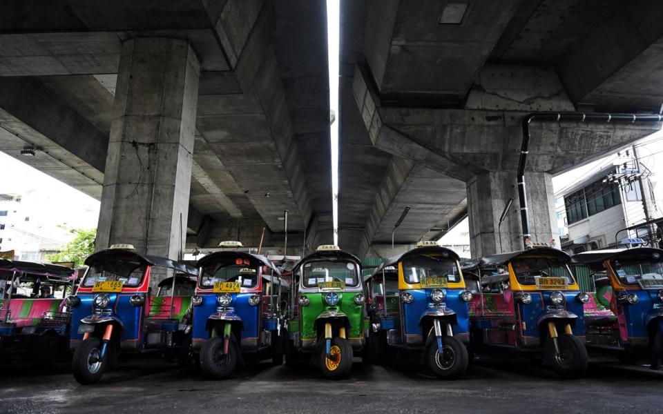 This photo taken on July 20, 2021 shows rows of "tuk-tuks" in a parking lot, as drivers remain out of work due to the economic hardship of Covid-19 and more than a year of no incoming foreign tourism, in Bangkok. - Tuk-tuks sitting idle, taxis crammed into empty lots -- just some of the vehicles taken off Bangkok's normally riotous roads and stashed in storage as a Covid surge decimates tourism and travel, leaving drivers out of pocket. - AFP