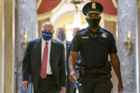 FILE - In this Aug. 5, 2020, file photo Postmaster General Louis DeJoy, left, is escorted to House Speaker Nancy Pelosi's office on Capitol Hill in Washington. The U.S. Postal Service has sent letters to 46 states and the District of Columbia, warning it cannot guarantee all ballots cast by mail for the November election will arrive in time to be counted, The Washington Post reported Friday, Aug. 14. DeJoy, a former supply-chain CEO and a major donor to President Donald Trump and other Republicans, has pushed cost-cutting measures to eliminate overtime pay and hold mail until the next day if postal distribution centers are running late. (AP Photo/Carolyn Kaster, File)