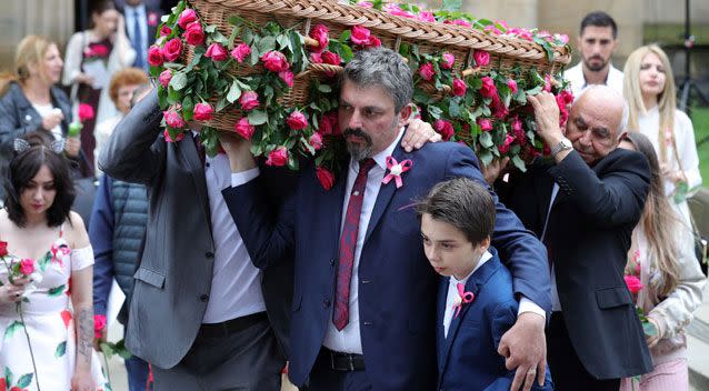 Andrew Roussos, the father of Saffie Roussos holds his son Xander Roussos whilst carrying the coffin of his daughter following the funeral of the young Manchester Attack victim at Manchester Cathedral. Source: Getty Images