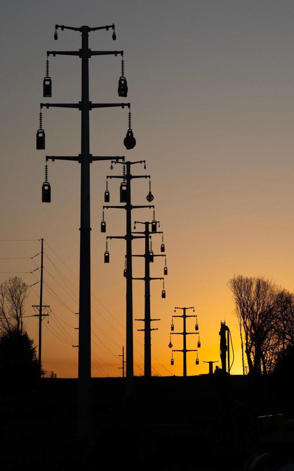 Recently installed 100-foot power poles carry 115,000-volt electrical transmission lines across residential properties on 95th Street in De Soto. Tammy Ljungblad/Tljungblad@kcstar.com