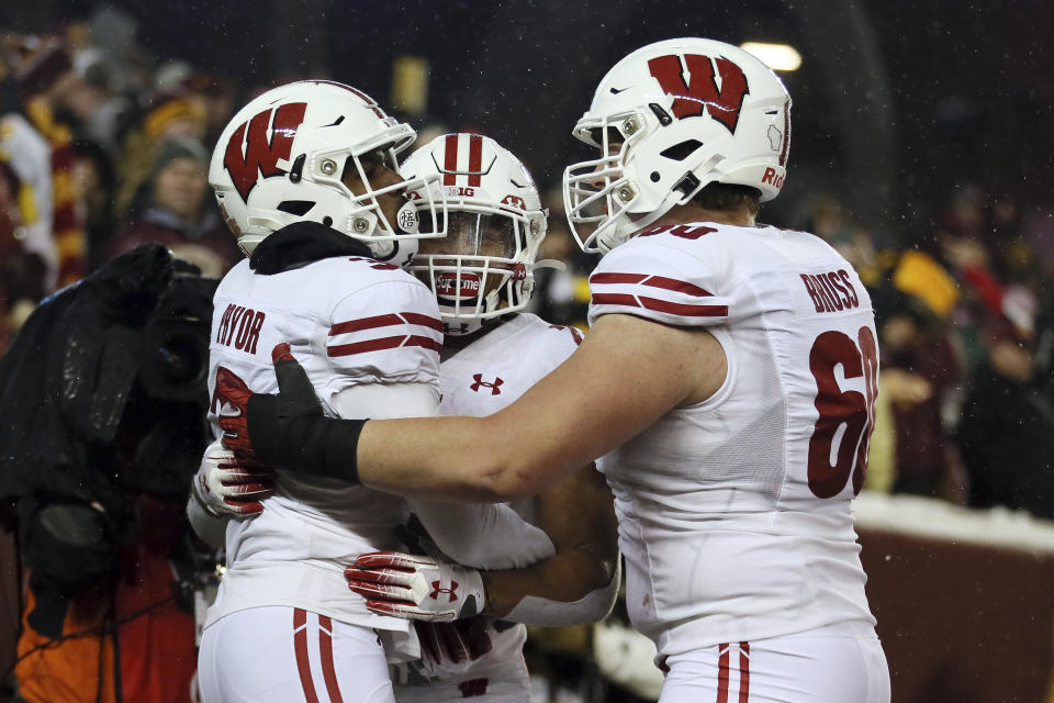 Wisconsin wide receiver Kendric Pryor, left, celebrates with teammates running back Jonathan Taylor, center, and offensive lineman Logan Bruss, right, after Pryor scored a touchdown against Minnesota during an NCAA college football game Saturday, Nov. 30, 2019, in Minneapolis. Wisconsin won 38-17. (AP Photo/Stacy Bengs)