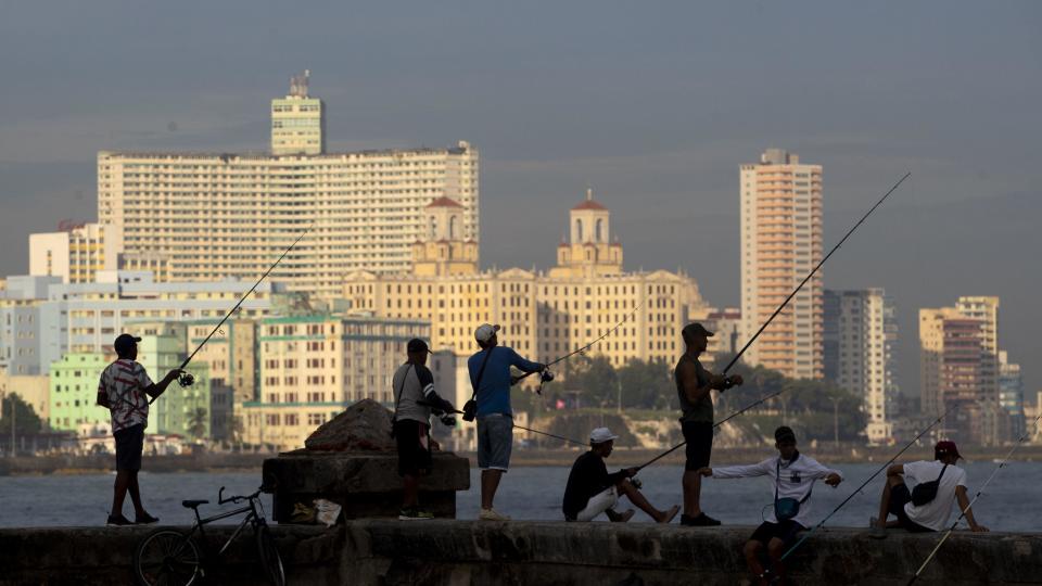 Cubanos pescan en el malecón