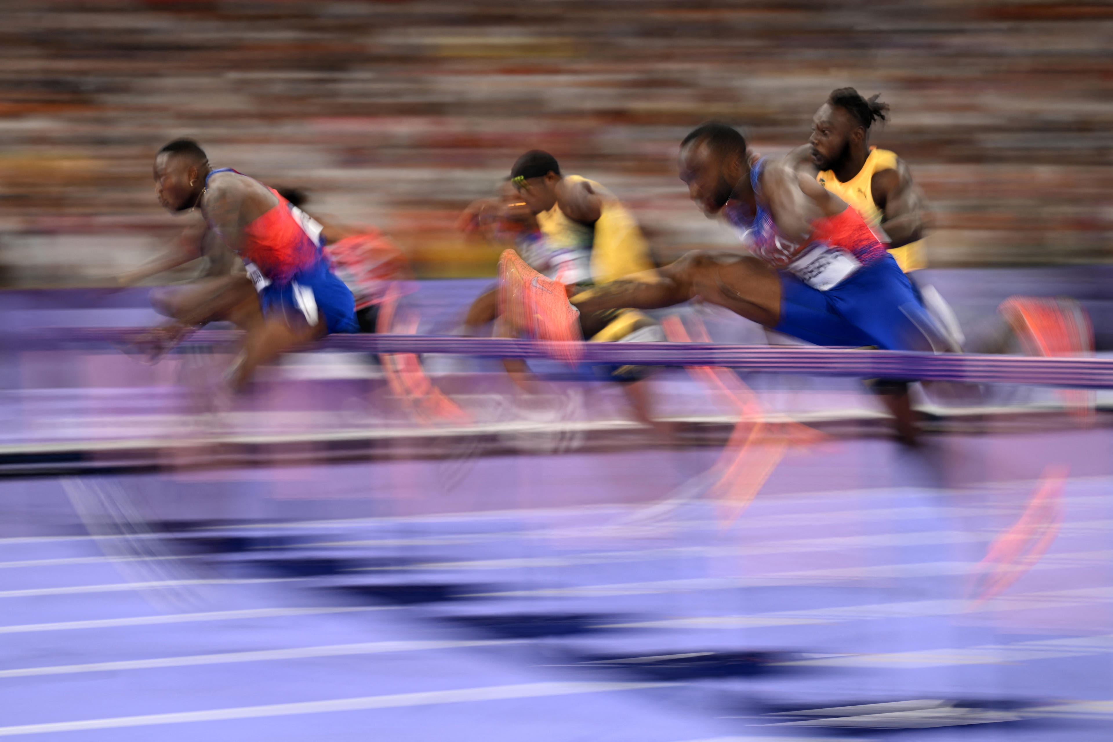 US' Grant Holloway (L) competes in the men's 110m hurdles final of the athletics event at the Paris 2024 Olympic Games at Stade de France in Saint-Denis, north of Paris, on August 8, 2024. (Kirill Kudryavtsev/AFP/Getty Images)