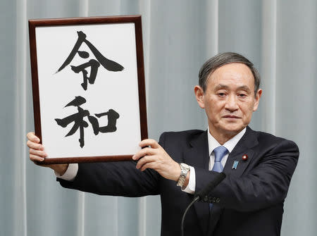 Japan's Chief Cabinet Secretary Yoshihide Suga unveils the new era name "Reiwa" at a news conference in Tokyo, Japan, April 1, 2019, in this photo taken by Kyodo. Mandatory credit Kyodo/via REUTERS