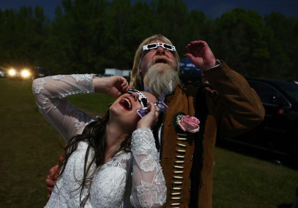 A bride and groom watch the solar eclipse in Arkansas in 2024