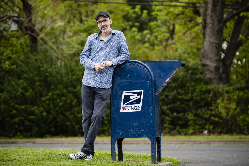 In this Tuesday, May 5, 2020, photo, filmmaker Tom Quinn poses for a photograph in Warminster, Pa. Quinn set out to make a movie about a town that lost its zip code, and its place on the map, in a round of USPS closures in 2011. The film became a study in loneliness. (AP Photo/Matt Rourke)