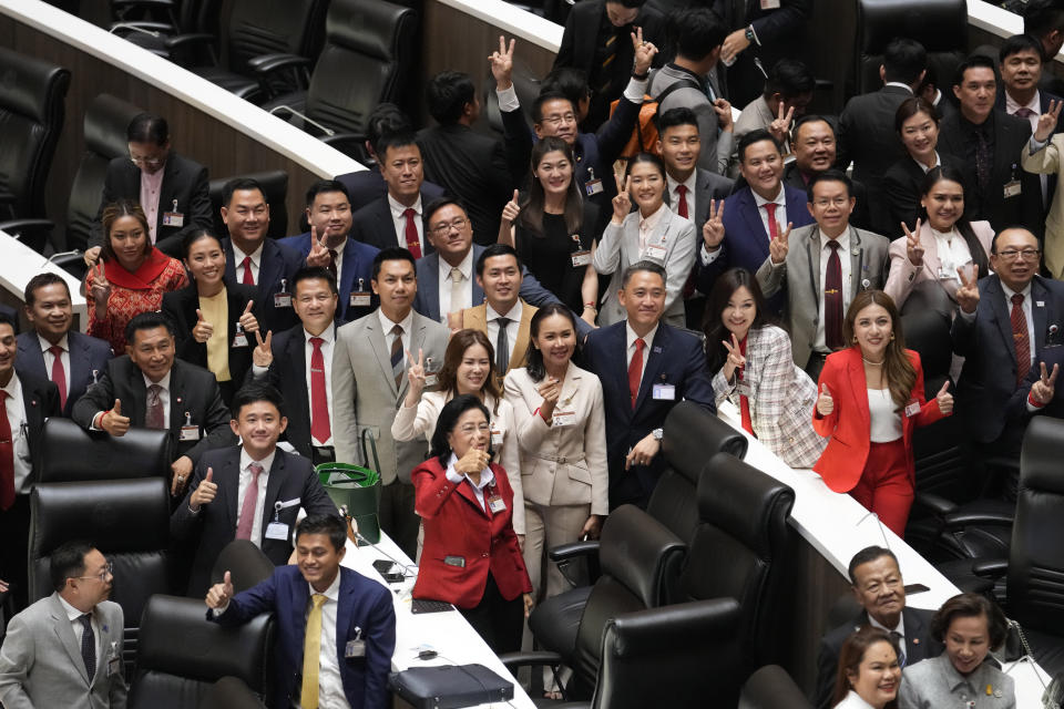 Pheu Thai party lawmakers make victory signs at Parliament in Bangkok, Thailand, Tuesday, Aug. 22, 2023, after securing enough votes in parliament for their nominee Srettha Thavisin to become Thailand's 30th prime minister. (AP Photo/Sakchai Lalit)