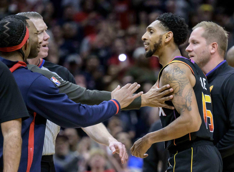 New Orleans Pelicans head coach Willie Green, second from left, puts his hand on Phoenix Suns guard Cameron Payne (15) at the end of an NBA basketball game in New Orleans, Friday, Dec. 9, 2022. (AP Photo/Matthew Hinton)