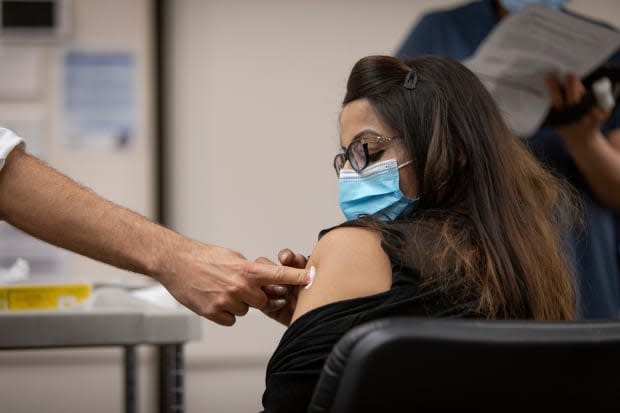 An employee of Apotex pharmaceuticals gets her first dose of the Moderna COVID-19 vaccine at a mobile clinic run by Humber River Hospital on Tuesday. (Evan Mitsui - image credit)