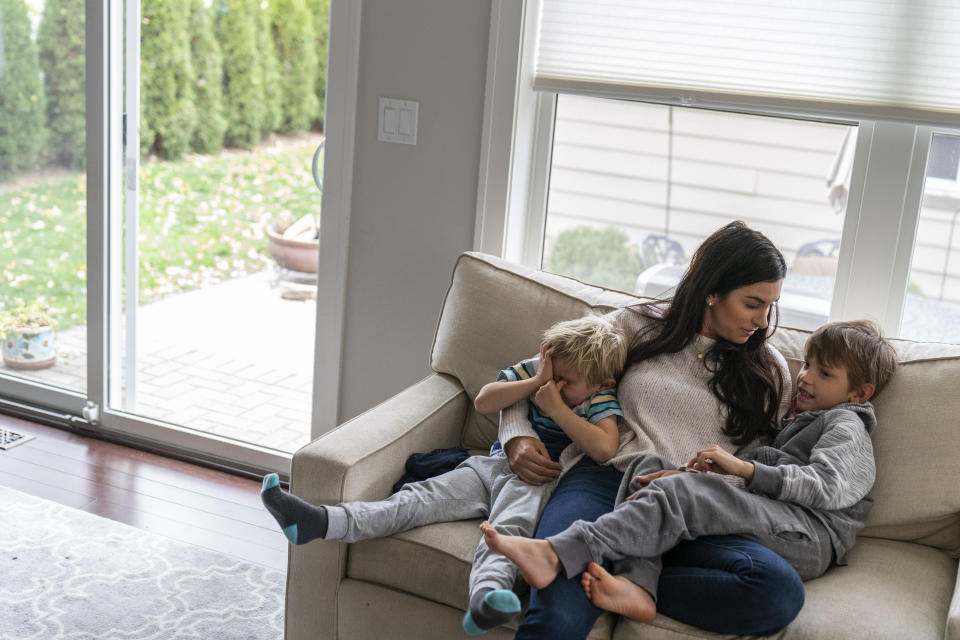 Meghan Iliesiu sits with her sons, Gabriel, 6, right, and Alexander, 4, at their home in Huntington Woods, Mich., Friday, Oct. 30, 2020. Iliesiu, a 32-year-old stay-at-home mother in Oakland County, voted third-party in 2016. She never thought Trump would win. Now she believes he's made the country more hateful and divided. She decided long ago to vote for any Democrat who ran against him. Now the wait is excruciating, Iliesiu said. (AP Photo/David Goldman)