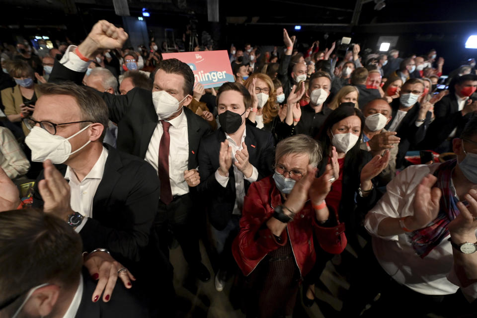 Guests at the SPD Social Democrat Party election party for the state elections in Saarland celebrate to the first projections, in Saarbrucken, Germany, Sunday March 27, 2022. Exit polls indicate that German Chancellor Olaf Scholz’s center-left Social Democrats are headed for a clear election win in a western state that its conservative rivals have led since 1999. (Arne Dedert/dpa via AP)